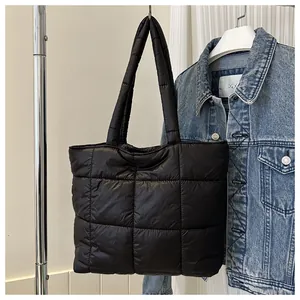 Close-up of black quilted down tote bag featuring classic square stitching and nylon texture