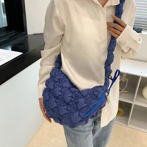 Detail of dark blue cloud bag with ruched strap and quilted bubble texture finish