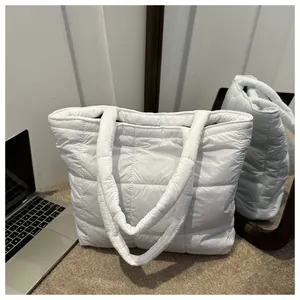 Detail of white quilted tote bag featuring puffer texture and square stitched pattern