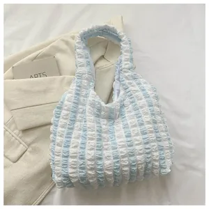 Detailed close-up of blue and white striped puff fabric on a summer tote bag