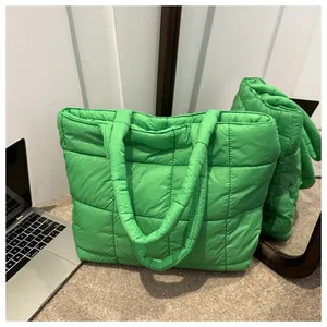 Detailed close-up of grass green quilted down tote bag with a soft puffer square pattern