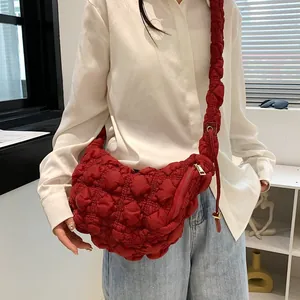 Deep red quilted cloud bag with puffy bubble texture and ruffled shoulder strap shown on model