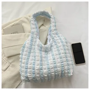 Close-up of puffy bubble fabric texture on blue and white striped tote shoulder bag
