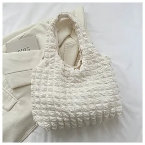 Detail of off-white popcorn texture fabric and seamless handle on the tote bag