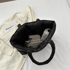 Black quilted puffer tote bag with large capacity showing umbrella and phone storage