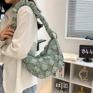 Close-up of mint green pleated cloud bag featuring textured bubble fabric and shoulder strap