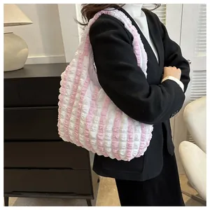 Pink and white striped cloud puff bag with bubble texture on female model shoulder