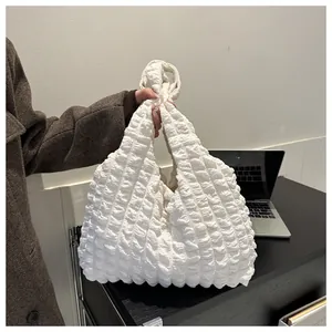 Detail of white bubble cloud bag texture showing 3D popcorn pleated fabric and soft handle