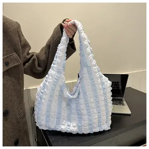 Detail of light blue and white striped puffy tote bag with soft 3D bubble fabric texture
