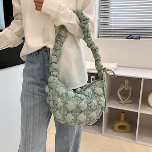Detail of light green pleated bubble bag texture and crescent shape on model shoulder