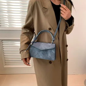Minimalist blue marble texture crossbody bag with unique knot handle shown on model