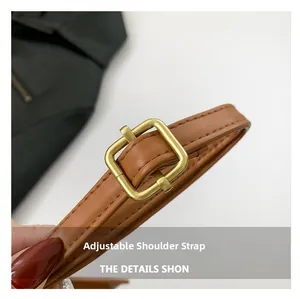 Detail of brown leather adjustable shoulder strap with premium golden metal buckle