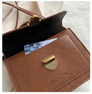 Detailed view of the brown vintage small square bag with a front storage pocket