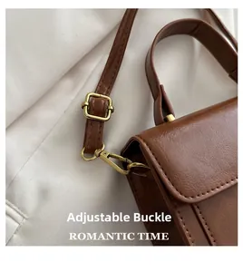 Detail of vintage brown leather bag with golden adjustable buckle and strap