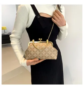 Detalle de bolso vintage con estampado de tréboles y cierre elegante de metal dorado