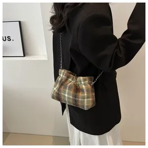 Detail of vintage plaid wool tote bag with chain strap shown on model shoulder