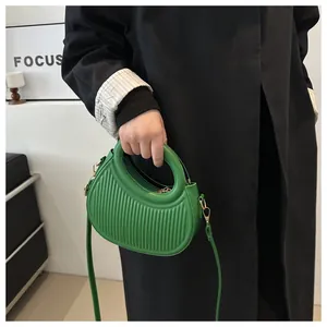 Dettaglio della borsa hobo verde smeraldo a pieghe con hardware dorato e manico tondo