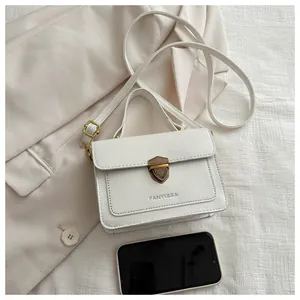 Detail of cream PU leather handbag with vintage metal shield lock and brand lettering