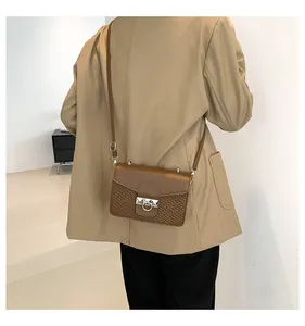 Detail of trendy crossbody bag featuring textured woven pattern and elegant metal clasp