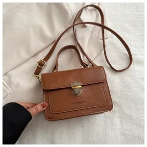 Close-up of a vintage brown leather small square bag with metallic shield lock