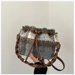 Close-up of tricolor checkered wool bucket bag with woven strap and drawstring detail
