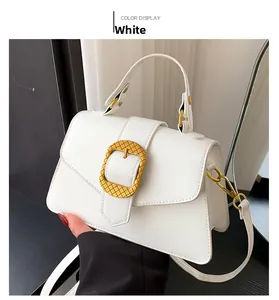 Detail of white PU leather handbag with large gold buckle and adjustable strap