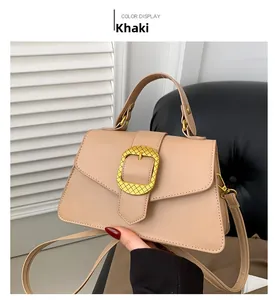 Detail of khaki leather handbag with large gold buckle and adjustable shoulder strap