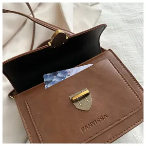 Detailed view of the brown retro bag's interior compartment and vintage metal lock