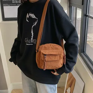 Vintage brown corduroy crossbody bag with flap pocket and woven zipper pull strap