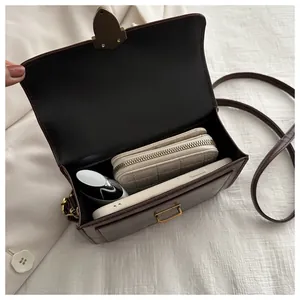 Close-up of the spacious brown leather bag interior with golden lock and daily essentials