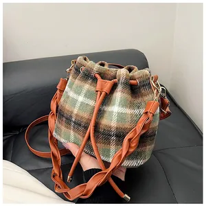 Macro shot of wool plaid texture on vintage drawstring bucket bag with leather strap