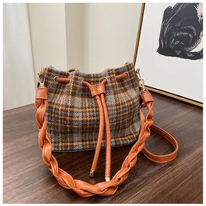 Detailed shot of retro plaid woolen bucket bag with woven strap and drawstring close