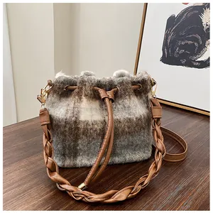 Detailed view of the plaid wool bucket bag featuring soft plush texture and woven brown handle