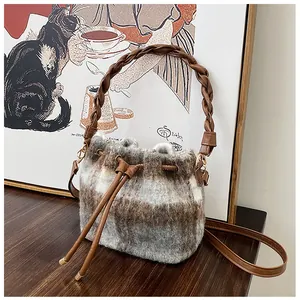 Detailed close-up of plaid wool bucket bag with leather handle and drawstring closure