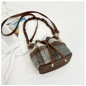 Detail of checkered wool bucket bag with leather drawstring and gold metal eyelets