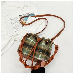 Top-down view of retro plaid wool bucket bag with brown leather trim and woven handle
