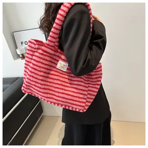 Detail of red and pink striped plush tote bag showing soft fuzzy texture and brand label