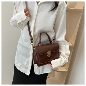 Close-up of retro brown leather handbag with metallic shield lock and premium texture