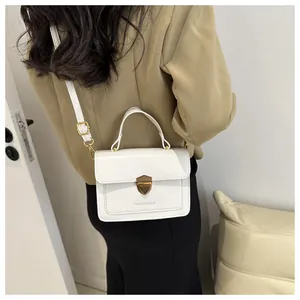 Detailed view of white structured bag with golden shield lock and FANYISSA logo detail