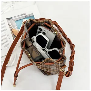 Inside view of wool plaid bucket bag showing space for phone, sunglasses and cosmetics