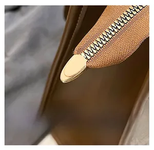 Close-up of premium golden metal zipper detail on brown leather large tote bag