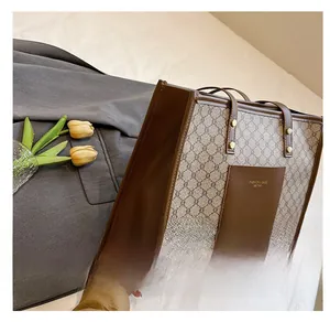Side profile of a large brown monogram tote bag with leather拼接and gold rivet details
