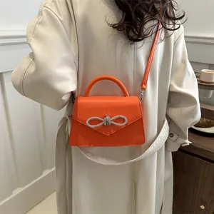 Fashion orange crossbody handbag with silver rhinestone bow and leather top handle strap