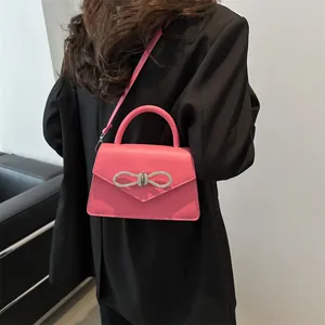 Pink crossbody handbag for women featuring a sparkling rhinestone bow and envelope flap