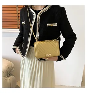Detailed close-up of yellow chevron quilted crossbody bag with gold chain and turn-lock