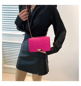 Detail of rose pink quilted leather shoulder bag with a metal turn-lock and chain strap