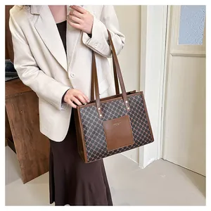 Close-up of vintage geometric monogram pattern and leather patch on tote bag