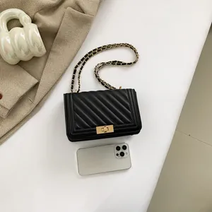 Chic black quilted crossbody bag with golden chain strap and metallic lock closure