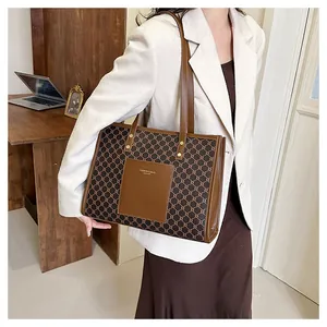Detail of vintage monogram tote bag with brown leather pocket and gold fashion text