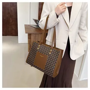 Detail of vintage tote bag with geometric pattern and brown leather pocket on model